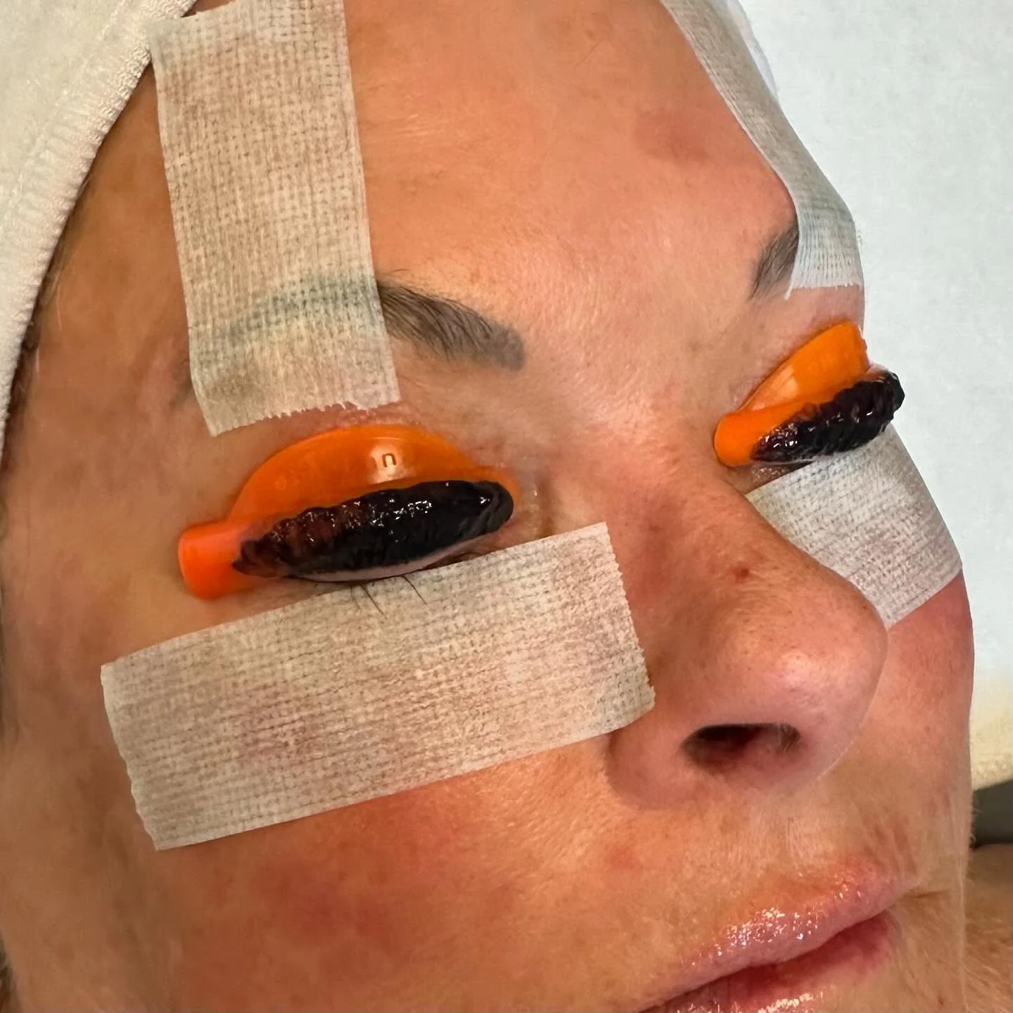 Lash lift in progress with silicone rods